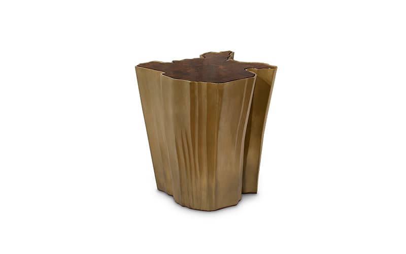A unique side table with an irregular, organic-shaped top surface. The base is sculpted with vertical, flowing lines that give it a textured, almost liquid appearance. The overall form evokes a natural element, possibly inspired by tree trunks or rock formations. The top has a darker, mottled texture contrasting with the metallic base. — 3D model