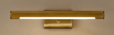 A horizontal, elongated wall-mounted LED light fixture, crafted from brass or a brass-toned metal. The main cylindrical body features a distinct ribbed texture and emits light from a continuous strip along its bottom edge. It is affixed to the wall by a rectangular mounting plate, creating a minimalist and functional aesthetic. — 3D model