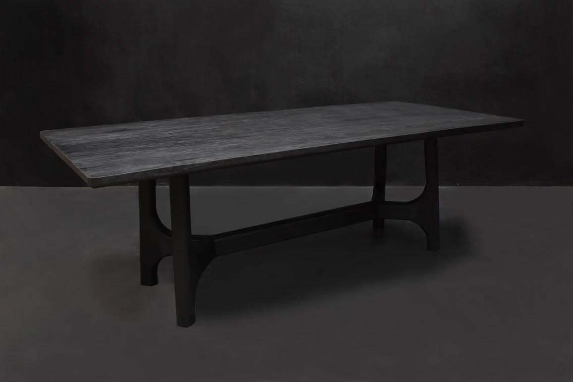 A rectangular dining table crafted from dark-stained wood, featuring a subtly textured tabletop and a robust trestle base with integrated stretcher bar. The entire piece is finished in a deep, almost black hue. — 3D model