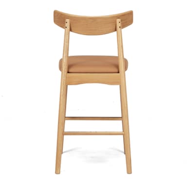 A modern bar stool featuring a light oak wood frame, a gently curved backrest, and a tan leatherette padded seat. It is designed with integrated footrests and straight, round tapered legs. — 3D model