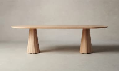 An oval-shaped dining table with a light wood finish. The tabletop is relatively thin with rounded edges. It is supported by two conical bases, each featuring a fluted or segmented design, tapering from a wider base to a narrower top where they connect to the underside of the tabletop. The bases appear to be made of solid wood. — 3D model