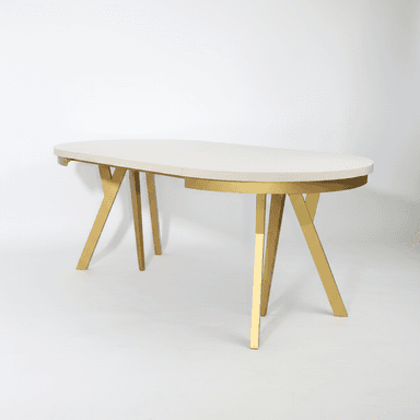 An oval-shaped dining table with a cream-colored top and a metallic gold base. The table top appears to be segmented, suggesting it might be extendable. The base consists of two angled, V-shaped legs that meet in the center, providing a modern and somewhat sculptural aesthetic. — 3D model