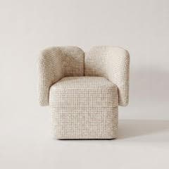 A modern armchair with a rounded, compact design. The chair features a cubic seat base and two curved, wing-like armrests that extend upwards and slightly outwards. The upholstery has a textured, woven appearance with a subtle checkered pattern. The overall form is soft and inviting. — 3D model