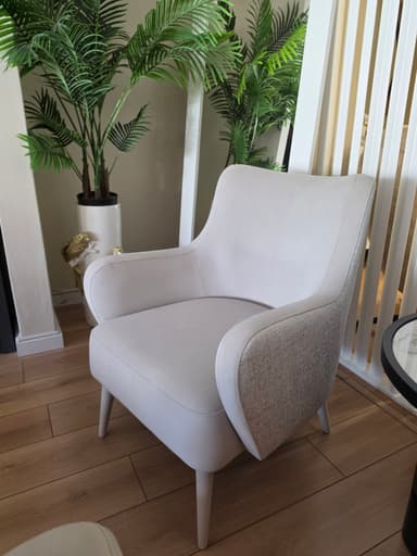 A modern upholstered lounge chair with a light-colored body, contrasting side panels, and tapered wooden legs, designed for comfort and style. — 3D model