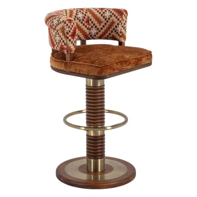 A swivel bar stool featuring a round upholstered seat in brown velvet and a curved, rolled backrest upholstered in a multi-patterned fabric. The central column consists of a brass top and bottom section flanking a distinctive ribbed or spiral-cut wooden segment. A circular brass footrest is integrated into the column, which rests on a round wooden base with a central brass inlay. — 3D model