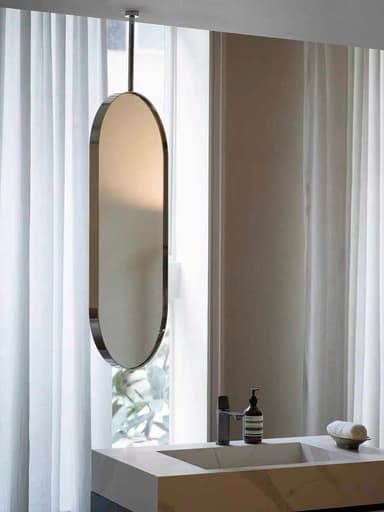 A tall, oval-shaped mirror featuring a polished metal frame, suspended vertically by a slender rod from the top. The design is sleek and minimalist, with smooth, rounded edges. — 3D model