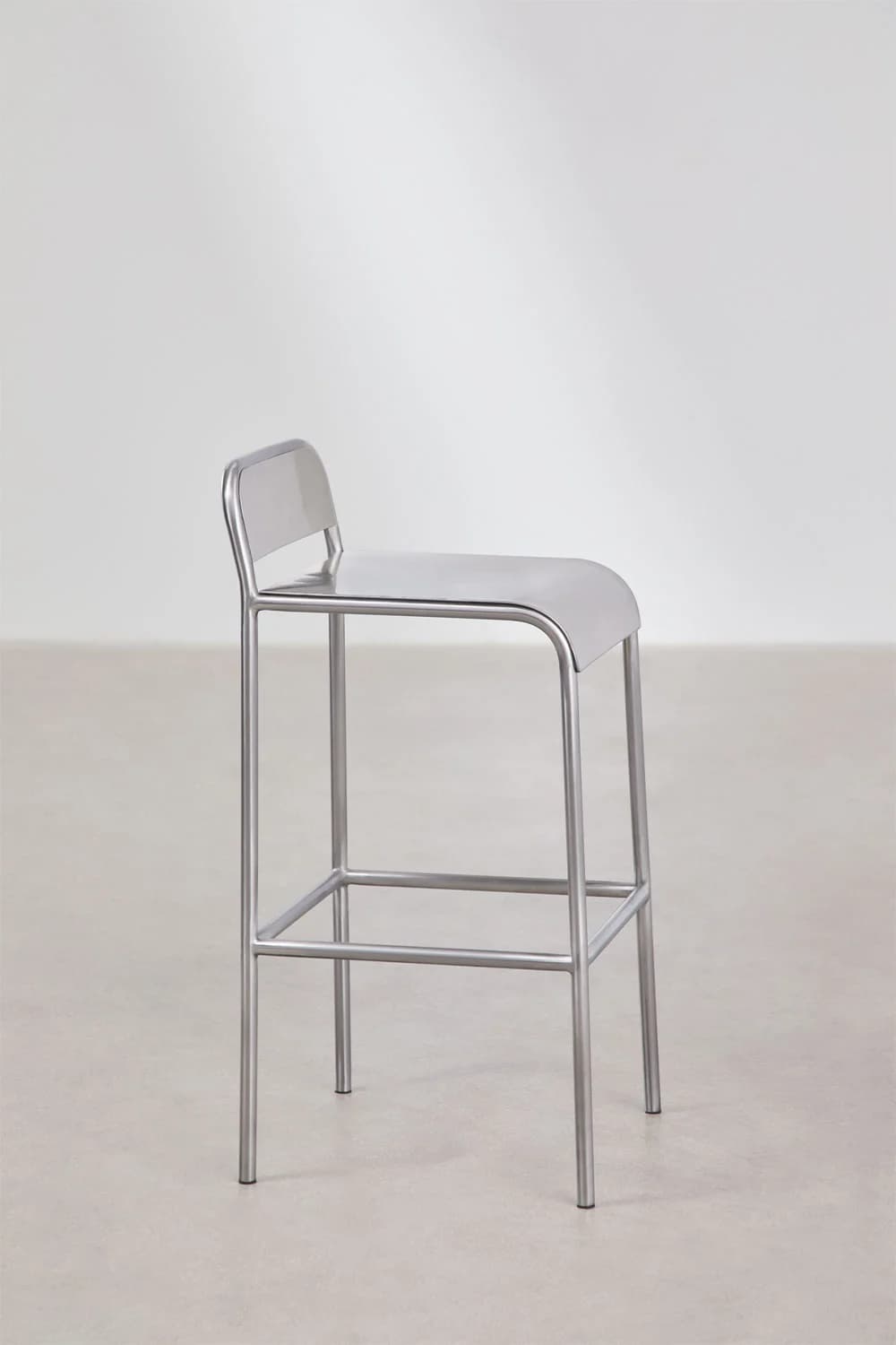 A minimalist industrial bar stool constructed entirely from brushed metal, likely stainless steel or aluminum. It features a tubular frame, a rectangular footrest, and an integrated seat and low backrest with rounded edges. — 3D model