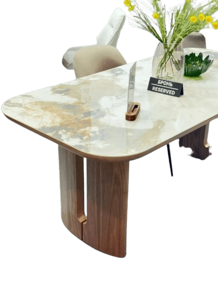 A contemporary coffee table featuring a rectangular top with rounded corners, crafted from a light-colored marble or marble-look material with prominent brown and grey veining. The base consists of two substantial, curved wooden legs made of dark brown wood, each appearing to be composed of two separate vertical panels, creating a sculptural and sturdy support. The overall aesthetic is sleek and modern. — 3D model