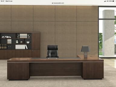 A modern U-shaped executive office desk featuring a dark wood veneer finish, a central black surface insert, and integrated flush-mounted power and data modules. A subtle silver accent strip runs along the edges, and the desk is supported by solid block bases. — 3D model