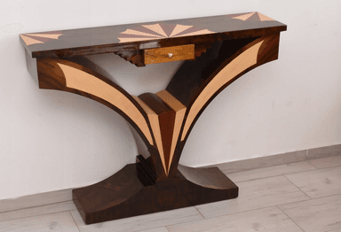 An elegant console table featuring a dark wood finish adorned with intricate marquetry. The rectangular tabletop displays a central sunburst pattern, flanked by geometric designs in contrasting lighter wood. The table's base consists of two large, sweeping curved supports that meet at a central point and transition into a sturdy, ornate plinth. These legs are also embellished with contrasting wood inlays that highlight their graceful, sculptural form. A single, small drawer with a simple pull is subtly integrated beneath the tabletop. — 3D model