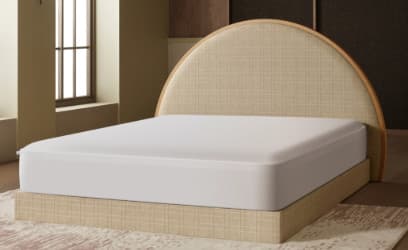 A contemporary upholstered platform bed featuring a clean, minimalist design. The bed frame is fully upholstered in a light beige, textured fabric, providing a soft and integrated look. The headboard is a distinctive semi-circular shape, also upholstered in the same fabric, and framed by a light-toned wooden border. A standard white mattress is depicted resting on the platform. — 3D model