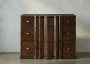 A dark brown wooden chest of drawers featuring a distinctive wavy or fluted front design on its central drawers, flanked by straight-front drawers on either side. All drawers are fitted with small, round brass knobs. The piece has a rich, visible wood grain. — 3D model