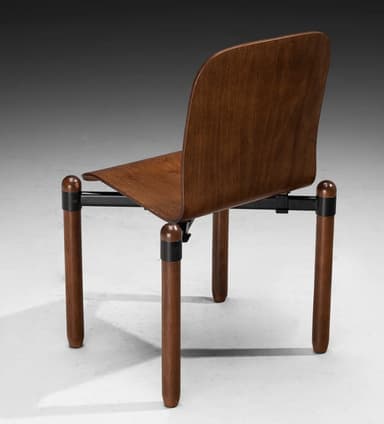A contemporary chair with a contoured wooden seat and backrest, supported by cylindrical wooden legs and a black metal frame. The design features a minimalist aesthetic with rounded edges. — 3D model