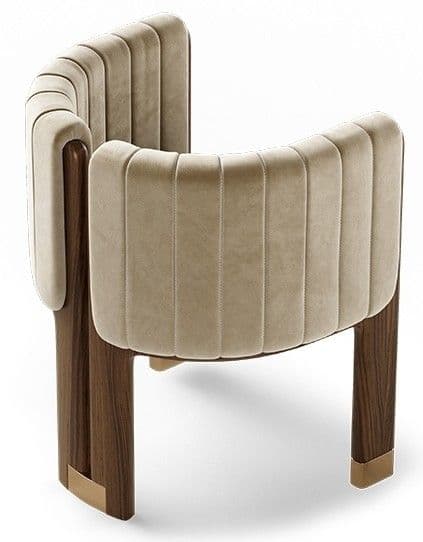 A luxurious contemporary accent chair featuring a curved, barrel-back design with integrated armrests, upholstered in channel-tufted beige velvet, supported by dark wood legs with brass caps. — 3D model