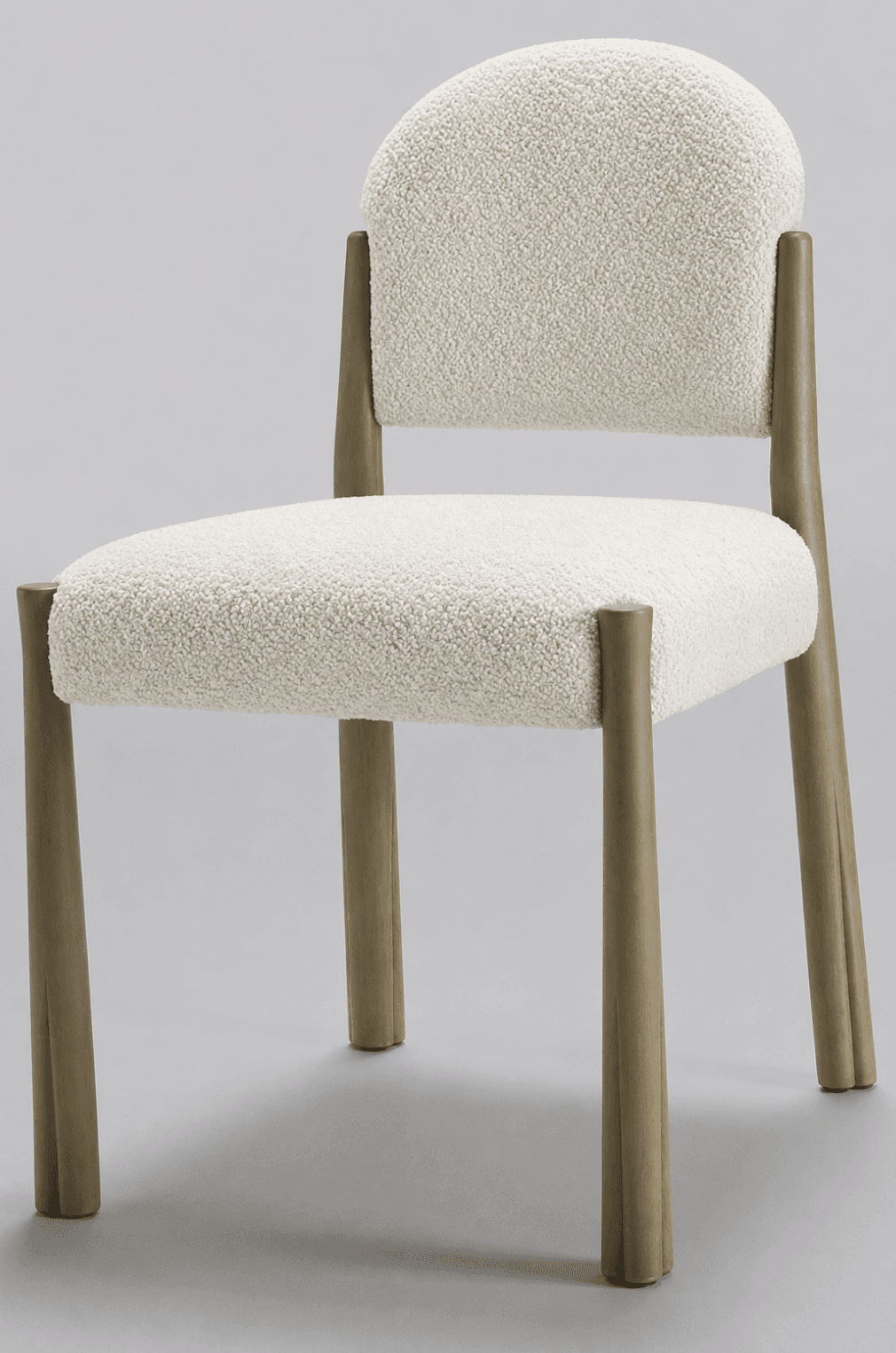 A contemporary dining chair featuring a rounded, padded backrest and seat, both upholstered in off-white boucle fabric. It is supported by four solid, tapered wooden legs with a light, natural finish, exhibiting subtle fluting at the base. — 3D model