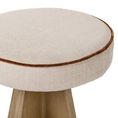 A contemporary bar stool with a tapered wooden base and a cushioned, upholstered seat. The base is constructed from light-colored wood with a distinct grain pattern and features a circular metal footrest. The seat is round, padded, and covered in a light-colored fabric, with a thin, contrasting trim around its edge. — 3D model