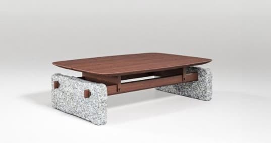 A low-profile coffee table featuring a rectangular wooden top with rounded edges, supported by a minimalistic wooden frame that connects to two substantial, rough-hewn stone bases. The design emphasizes a striking contrast between natural materials. — 3D model