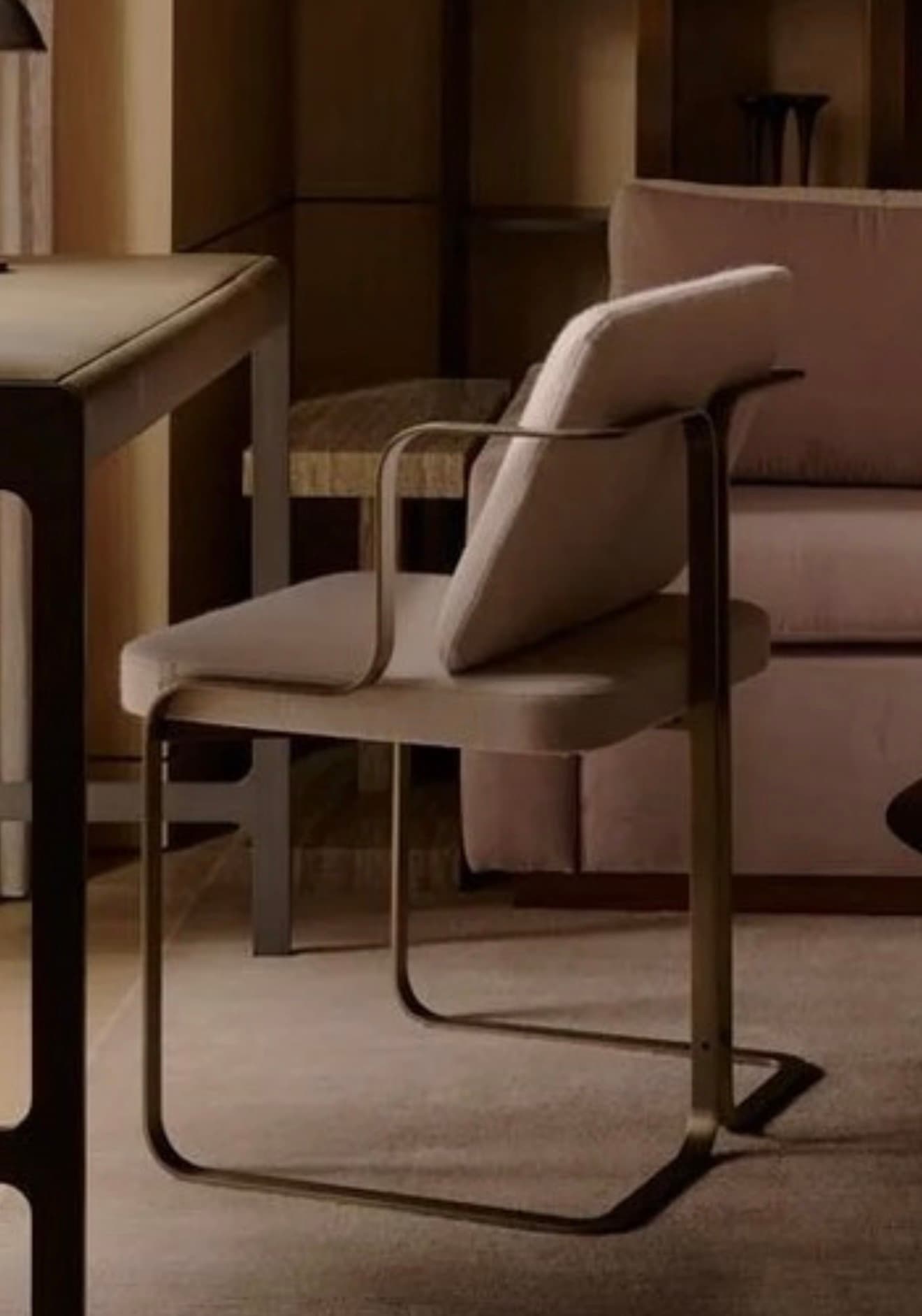 An armchair featuring a contemporary cantilever design with a continuous tubular metal frame in a dark finish. It has an upholstered seat and backrest, offering a minimalist yet comfortable seating solution. The armrests are integrated into the frame's sweeping lines. — 3D model
