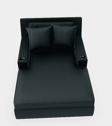 A contemporary, sleek black faux leather chaise lounge featuring a low backrest, broad fixed armrests with integrated metal cupholders, and two matching throw pillows. — 3D model