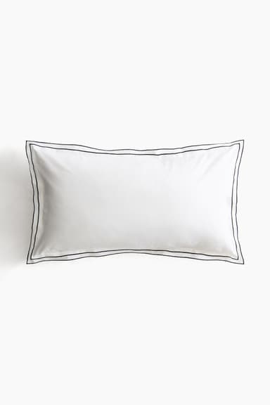 A white pillow with a rectangular shape, featuring a clean design with a double line of dark stitching around its perimeter. The pillow appears to be filled and covered with fabric, suggesting it is intended for sleeping or comfort. — 3D model