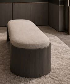 An elongated oval-shaped bench featuring a light-colored upholstered top and a solid, dark wood veneer base with rounded ends, presenting a clean and modern aesthetic. — 3D model