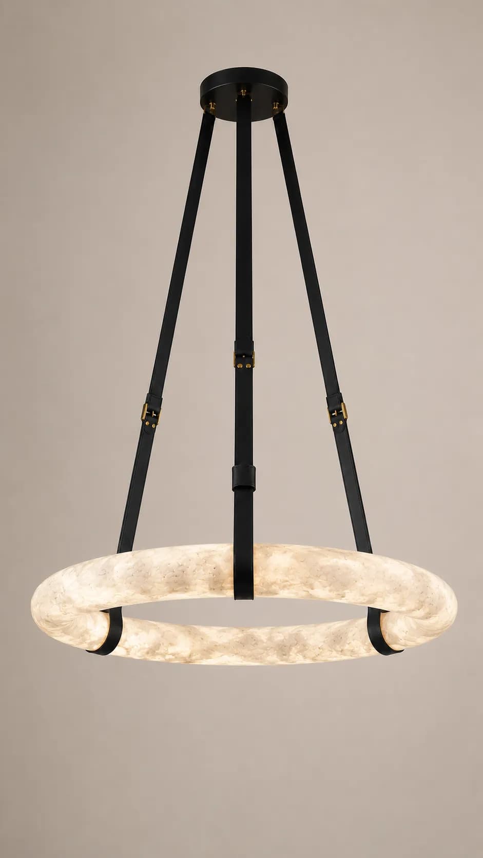 A modern circular pendant light featuring a large, illuminated off-white ring suspended by three black straps with brass-colored buckles from a black ceiling canopy. — 3D model
