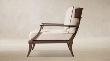 A contemporary lounge armchair featuring a dark-toned exposed metal frame and plush, light-colored upholstered cushions. The chair has a distinctive backrest with a wide, curved top rail and vertical support elements, complemented by straight, padded armrests. The legs are subtly tapered, contributing to a sleek and elegant profile. — 3D model