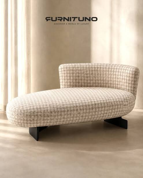 A contemporary chaise lounge upholstered in a beige and off-white houndstooth fabric, featuring a rounded, ergonomic form and supported by a minimalist black metal base. — 3D model