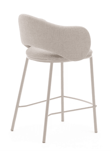 A contemporary bar stool featuring a fully upholstered seat and a curved backrest that subtly forms integrated armrests. The upholstery is a light beige, textured fabric. It is supported by four slender, straight metal legs that match the light color, and includes a circular metal footrest. — 3D model