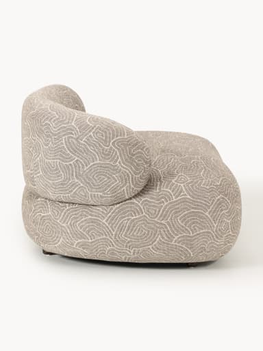 A modern, rounded armchair with a distinctive swirling pattern upholstery. It features a low profile and appears to be upholstered in a textured fabric. The base has short, dark-colored legs. — 3D model