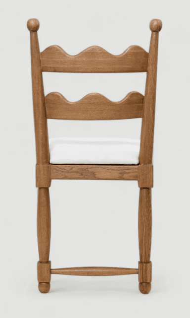 A wooden side chair with a cushioned seat, presented in a side profile against a plain background. The chair features a wooden frame with turned legs and stretchers. The backrest is composed of vertical wooden slats with decorative spherical finials at the top. The seat is upholstered in white fabric. — 3D model
