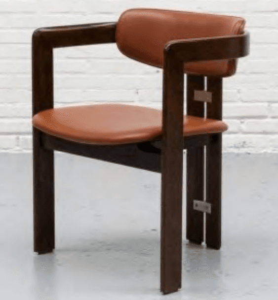 A modern armchair featuring a dark brown wooden frame with integrated armrests and a padded seat and backrest upholstered in cognac-colored faux leather. The chair exhibits clean, rectilinear lines for its frame components, which are visibly joined by metal plates and screws on the exterior of the rear legs. The backrest has a gentle curve at the top, and all wooden edges appear to be subtly rounded. The upholstery is smooth and unadorned. — 3D model