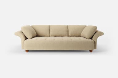 A three-seater sofa with a textured fabric upholstery. It features three back cushions and two plush armrest cushions. The base of the sofa is supported by four rounded wooden legs. The front upholstery of the seat cushion shows subtle button tufting. — 3D model