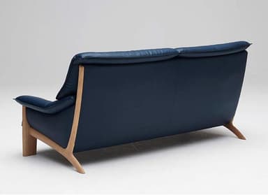 A mid-century modern style sofa upholstered in deep blue leather. It features a tufted backrest and seat cushions, with smooth, rounded armrests. The sofa is supported by a visible light wood frame, including legs and side supports, which contrast with the darker upholstery. — 3D model