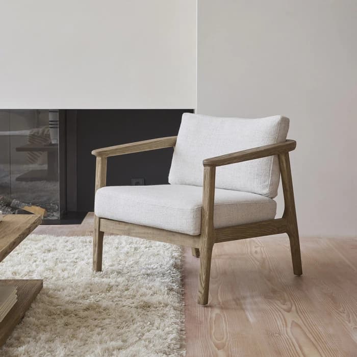 A modern armchair featuring an exposed light wood frame and light grey upholstered cushions. The design is clean and minimalist, highlighting the natural wood grain. — 3D model