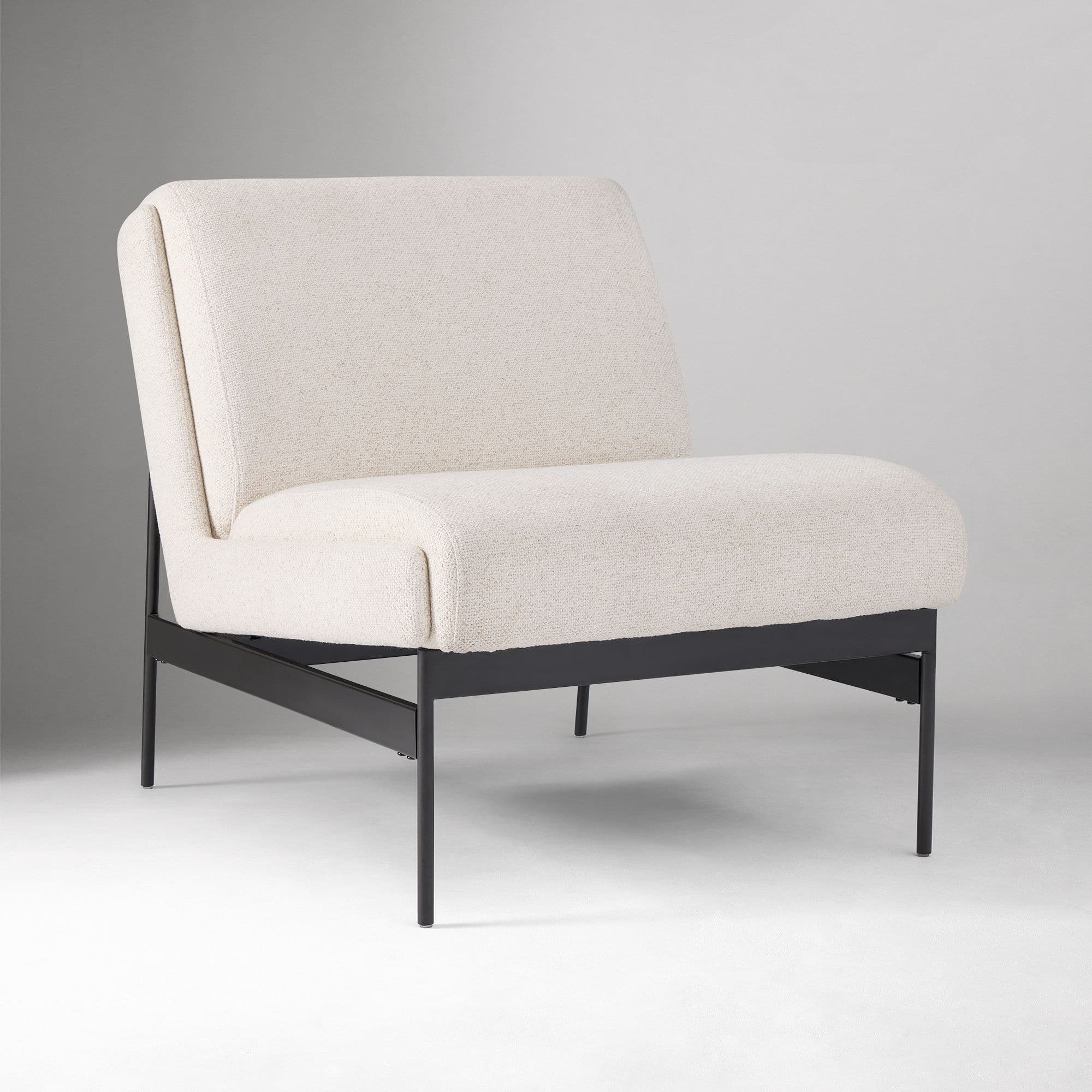 A modern armchair with a upholstered seat and backrest, supported by a slim, dark metal frame. The upholstery has a textured finish. The backrest is gently sloped, and the seat has a rounded front edge. The armrests are integrated into the upholstered structure. — 3D model