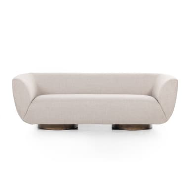 A modern sofa with a curved silhouette and a low-profile, round wooden base. The upholstery is a textured, light-colored fabric. The armrests seamlessly blend into the backrest, creating a continuous, flowing form. The base consists of two prominent, rounded wooden elements supporting the main body of the sofa. — 3D model