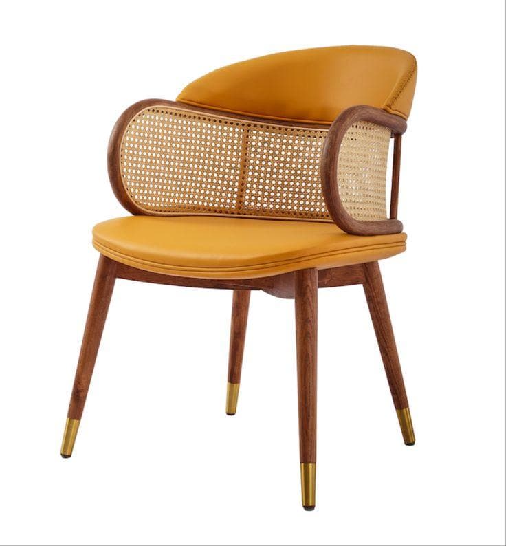 A contemporary armchair featuring a distinctive mid-century modern aesthetic. It has a rounded, upholstered seat and armrests in a vibrant mustard yellow hue, likely faux leather. The backrest incorporates a prominent cane weave panel framed by dark-stained curved wood, which also forms the armrests. The chair is supported by four tapered wooden legs, each tipped with a metallic brass-colored cap. — 3D model