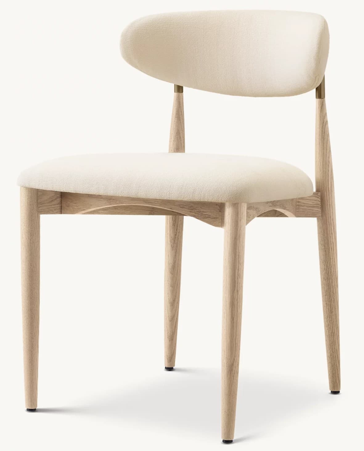 A contemporary dining chair featuring a light-toned wooden frame and cream-colored fabric upholstery. The chair has four tapered, splayed legs. The seat is a padded, upholstered slab, and the backrest is a distinct, curved, upholstered piece, supported by two vertical wooden posts that extend from the rear legs. Small brass elements appear to secure the backrest to its supports. The overall design emphasizes clean lines and natural materials. — 3D model