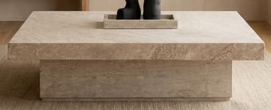 A rectangular, low-profile table constructed from light-colored travertine stone, featuring a thick, overhanging top slab supported by a smaller, recessed plinth base. — 3D model
