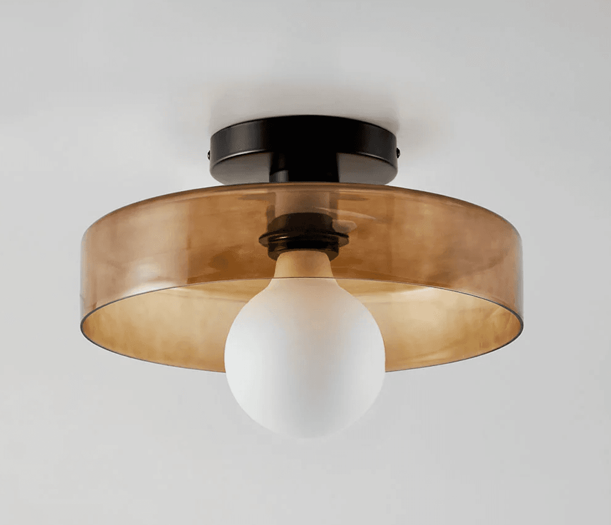 A semi-flush-mount ceiling light with a round black metal canopy, a transparent amber-tinted cylindrical glass shade, and a visible frosted white globe light bulb. — 3D model