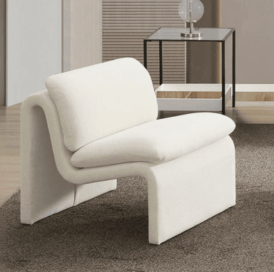 A modern, off-white armchair with a distinctive, sculptural design. The armchair features a low profile with a continuous, curved form that creates both the seat and the armrests/base. It has a separate, thick back cushion that rests against the curved structure. The upholstery appears to be a textured fabric. — 3D model
