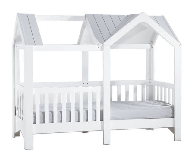 A white wooden bed frame designed to resemble a house, featuring a gabled roof structure and slatted side rails. The frame is constructed from solid wood with a clean white painted finish. A mattress is visible within the frame, indicating it is a complete bed setup. The design is whimsical and child-oriented. — 3D model