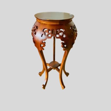 A round, carved wooden pedestal table featuring ornate East Asian-inspired openwork carvings on its apron and elegant S-curved legs. It has a single round top surface and a smaller lower shelf, all in a dark, warm brown finish. — 3D model