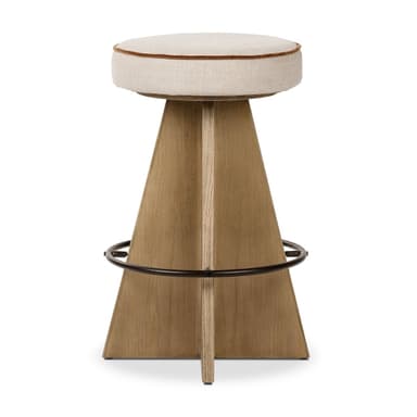 A contemporary bar stool with a tapered wooden base and a cushioned, upholstered seat. The base is constructed from light-colored wood with a distinct grain pattern and features a circular metal footrest. The seat is round, padded, and covered in a light-colored fabric, with a thin, contrasting trim around its edge. — 3D model
