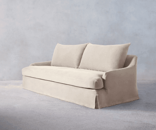 A plush, upholstered sofa with a skirted base and two back cushions. The sofa features rounded armrests that flow seamlessly into the frame. The upholstery appears to be a soft, textured fabric. — 3D model