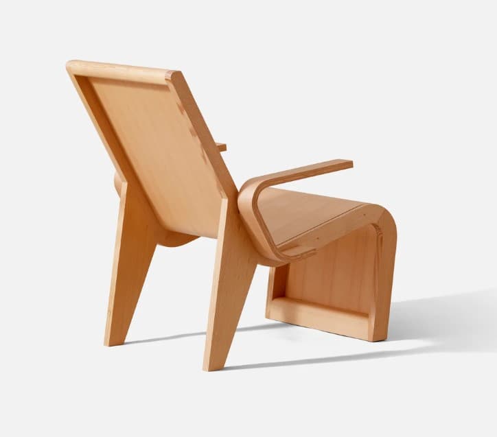 A modernist bent plywood lounge chair featuring a natural light wood finish. The design includes a low-slung, reclined backrest, a subtly curved seat, and integrated armrests, all formed from laminated wood sheets. The frame utilizes angular, broad supports, showcasing a minimalist and organic aesthetic with visible joinery. — 3D model