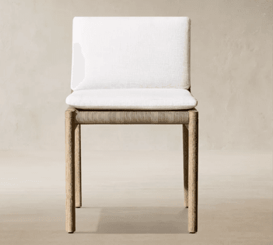 An armless dining chair featuring a light-toned solid wood frame, a seat base crafted from tightly woven natural fiber (appearing as rope or rattan), and removable upholstered cushions for both the seat and backrest in a white or off-white fabric. — 3D model
