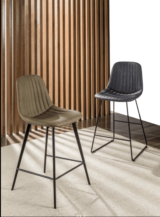 A modern bar stool featuring an olive green upholstered seat and backrest with vertical channel tufting, supported by sleek black tapered metal legs with an integrated footrest. — 3D model