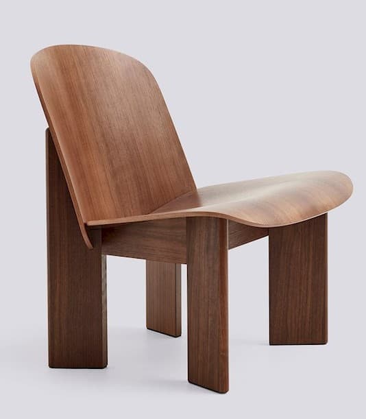 A low-profile lounge chair constructed from bent plywood, featuring a curved seat and backrest. The chair has a minimalist design with thick, block-like legs that provide support. The wood grain is visible, suggesting a natural wood veneer or solid wood construction. — 3D model